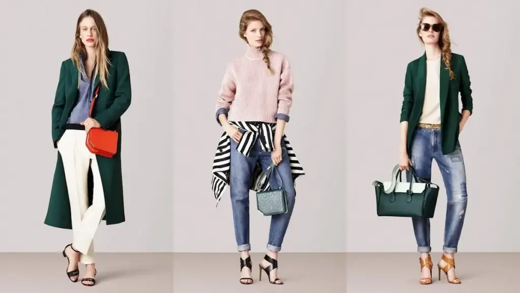 Three fashion models stand against a plain backdrop, showcasing different outfits. Left: Green coat, grey top, white pants, red purse. Middle: Pink sweater, striped shirt, blue jeans, green handbag. Right: Green coat, white top, blue jeans, green and white handbag.